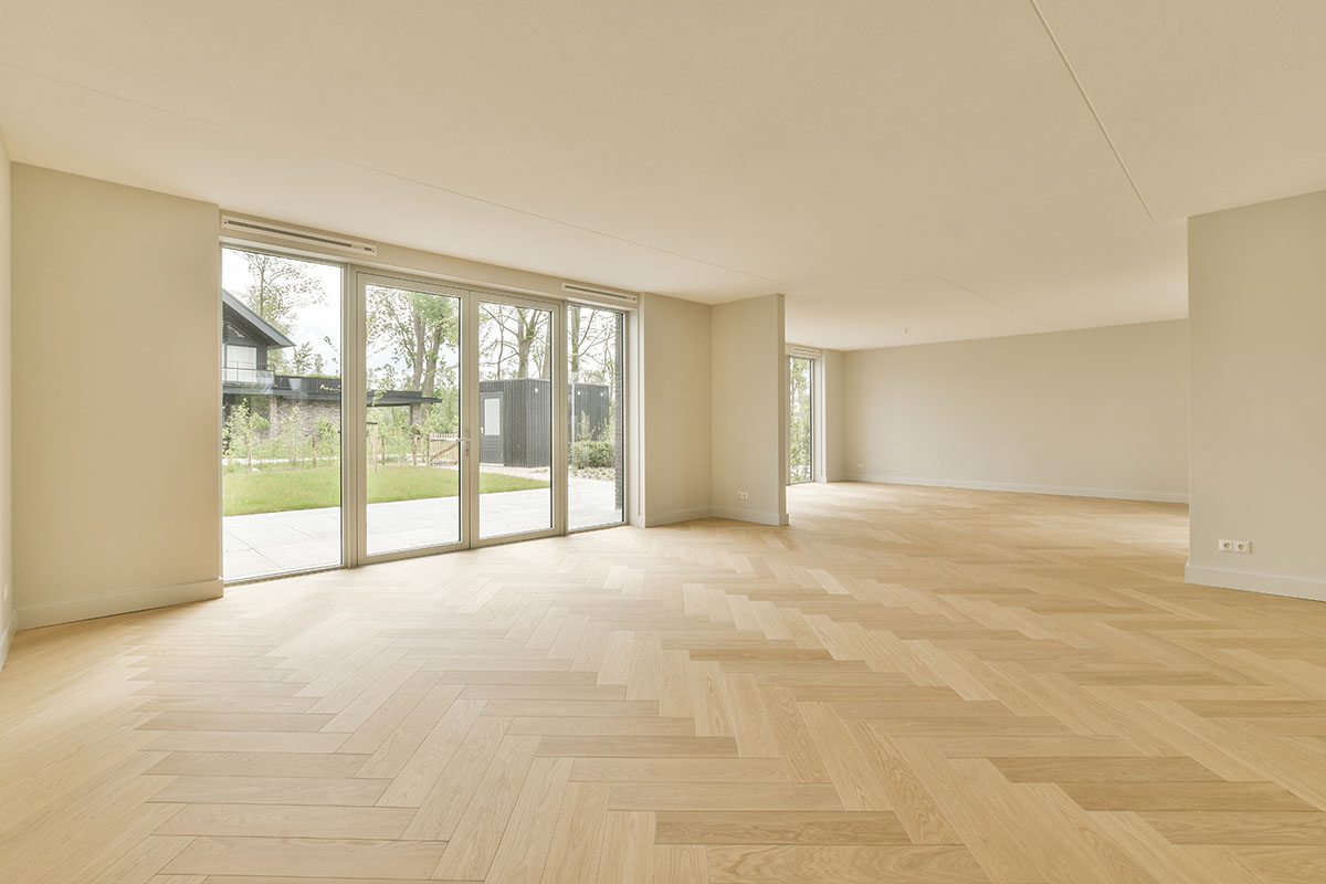 A Living Room With A Wooden Floor And Glass Doors